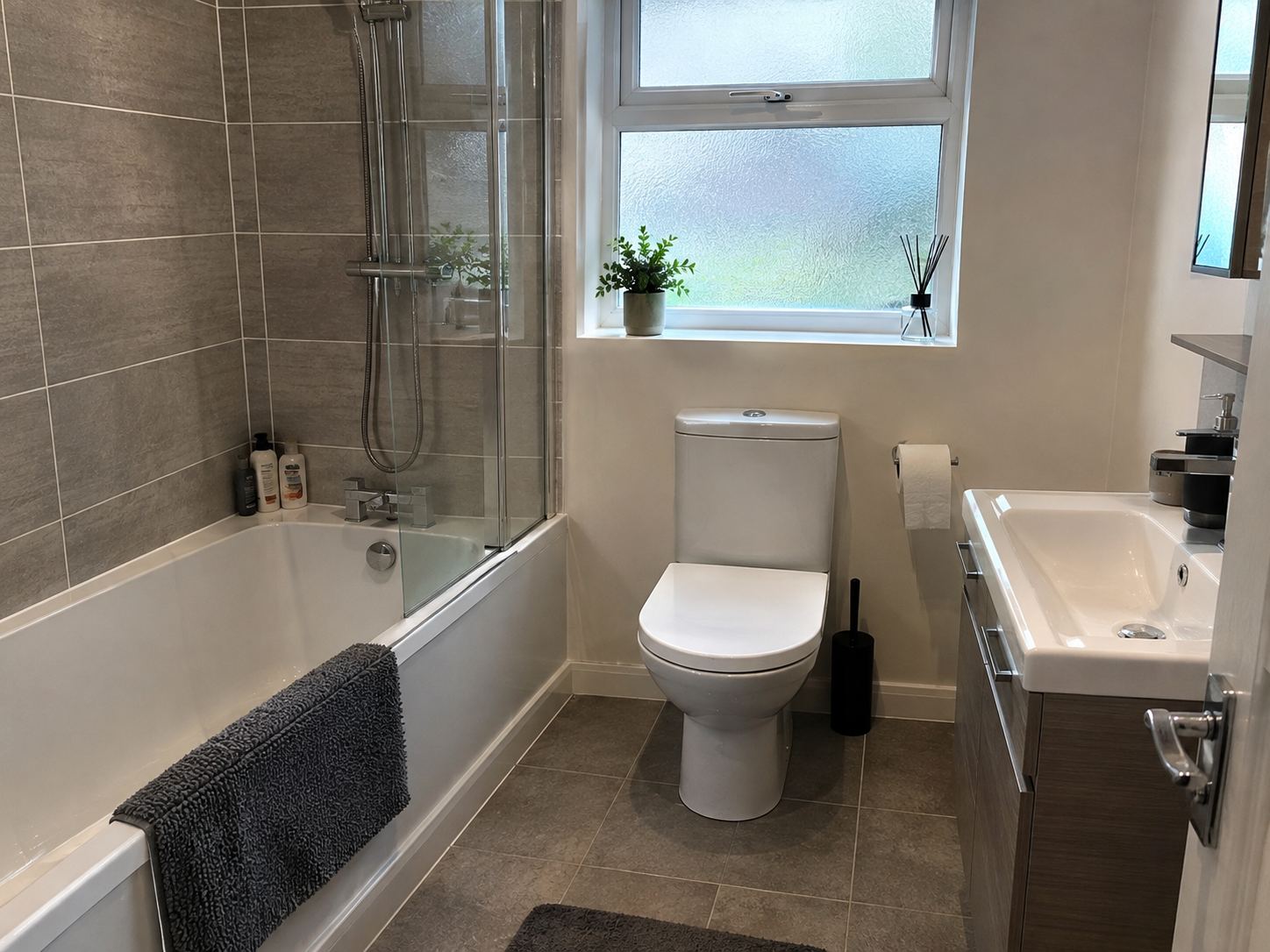 Spotless bathroom with clean bath, toilet and tiled floor