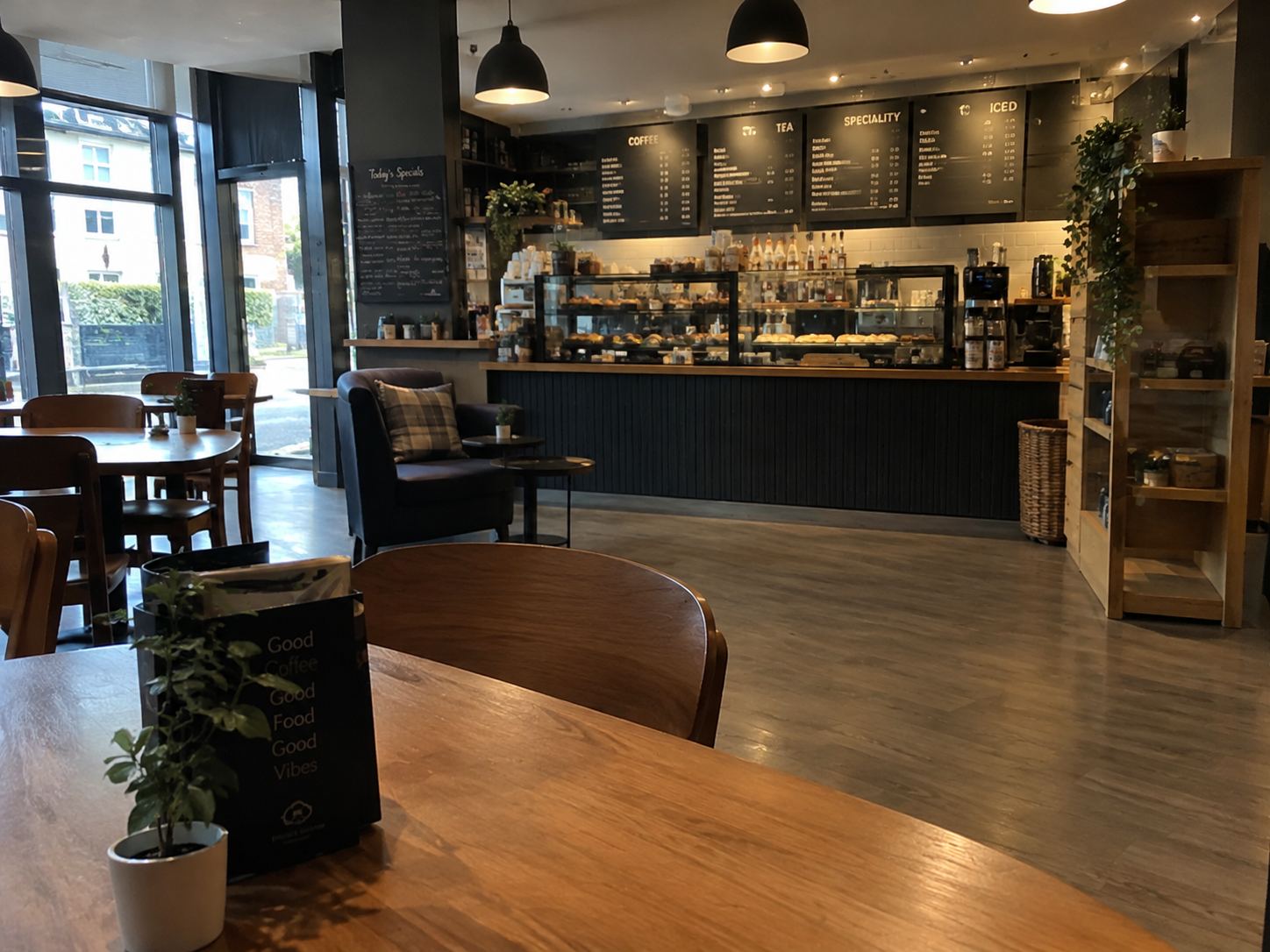 Clean, tidy café interior with wooden tables and counter